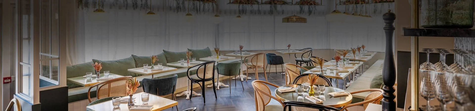 Salle du restaurant Bistrot Yonnais à La Roche-sur-Yon prête pour le menu de Noël, avec suspensions végétales, parquet en chevrons et tables dressées